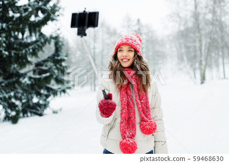 young woman taking selfie by monopod in winter young woman taking selfie by monopod in winter 59468630