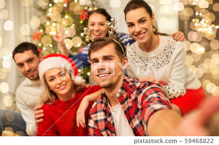 friends celebrating christmas and taking selfie 59468822