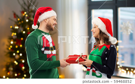 happy couple in sweaters with christmas gift happy couple in sweaters with christmas gift 59468852