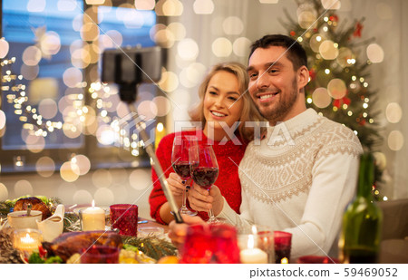 couple taking picture by selfie stick at christmas 59469052