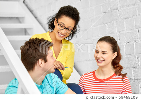 teenage friends or students hanging out on stairs teenage friends or students hanging out on stairs 59469109