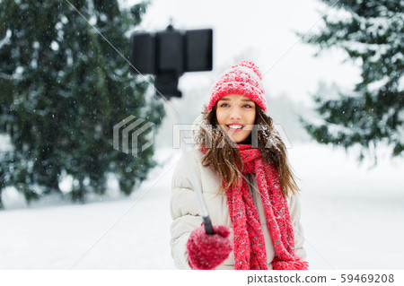 young woman taking selfie by monopod in winter young woman taking selfie by monopod in winter 59469208