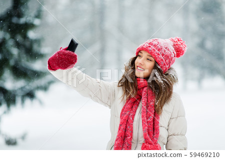 young woman taking selfie by smartphone in winter young woman taking selfie by smartphone in winter 59469210