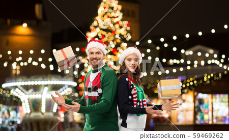 happy couple with gifts at christmas market 59469262