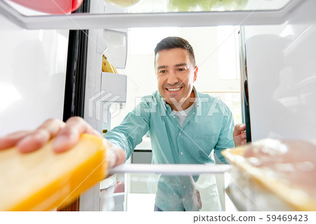 man taking food from fridge at kitchen 59469423