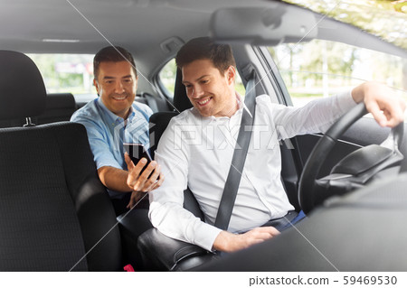 male passenger showing smartphone to car driver 59469530