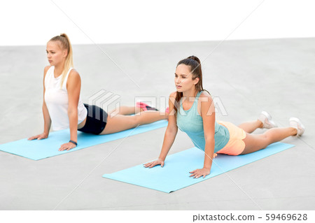 women doing sports on exercise mats outdoors 59469628