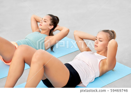 women training and doing sit-ups outdoors women training and doing sit-ups outdoors 59469746