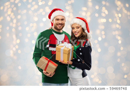 happy couple in sweaters with christmas gifts happy couple in sweaters with christmas gifts 59469748