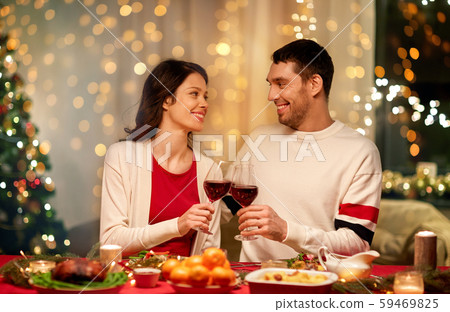 happy couple drinking red wine at christmas dinner 59469825