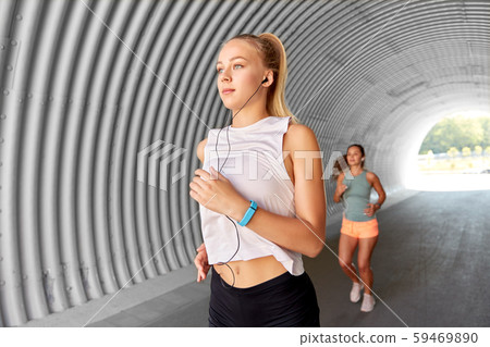 women or female friends with earphones running women or female friends with earphones running 59469890