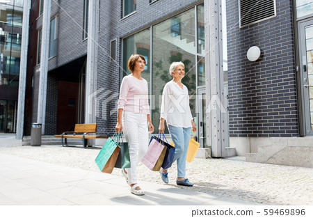 senior women with shopping bags walking in city senior women with shopping bags walking in city 59469896