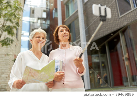 senior women with map and city guide taking selfie senior women with map and city guide taking selfie 59469899