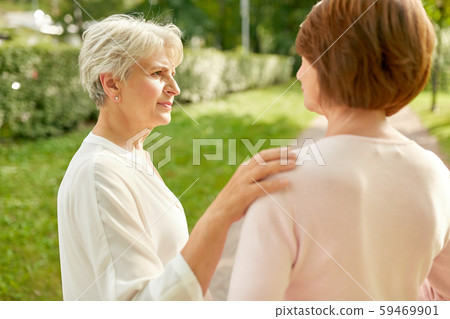 senior women or friends talking at summer park senior women or friends talking at summer park 59469901