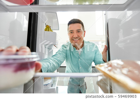man taking food from fridge at kitchen man taking food from fridge at kitchen 59469903