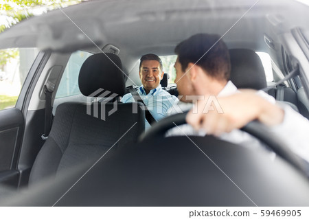 middle aged male passenger talking to car driver middle aged male passenger talking to car driver 59469905