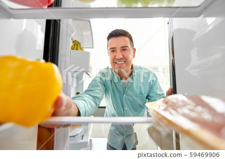 man taking vegetable from fridge at home kitchen man taking vegetable from fridge at home kitchen 59469906