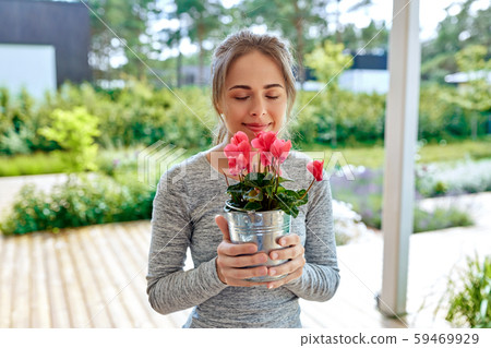 young woman with cyclamen flowers at summer garden 59469929