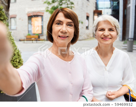 old women with shopping bags taking selfie in city old women with shopping bags taking selfie in city 59469932