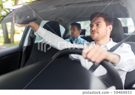 male driver with wireless earphones driving car 59469933