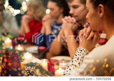 close up of friends praying at christmas dinner 59470096