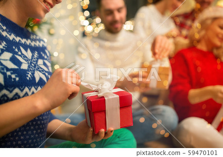 close up of friends opening christmas gifts close up of friends opening christmas gifts 59470101