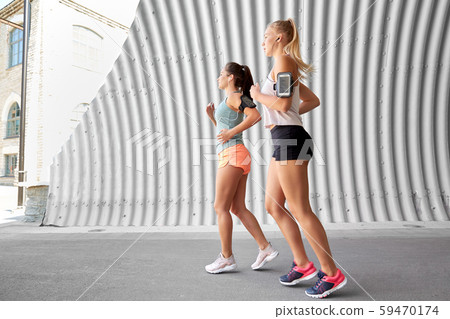 young women with earphones and smartphones running 59470174