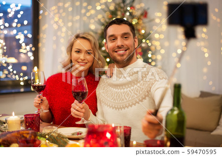 couple taking picture by selfie stick at christmas couple taking picture by selfie stick at christmas 59470595