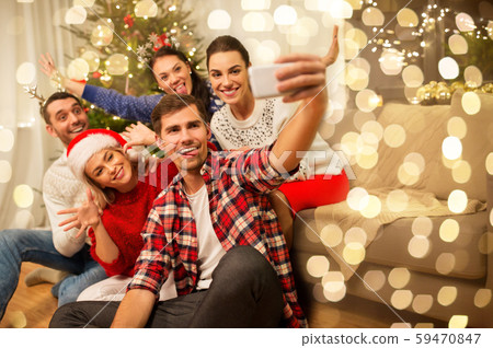 friends celebrating christmas and taking selfie 59470847