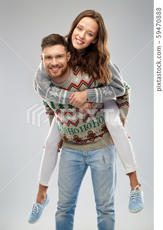 happy couple at christmas ugly sweater party 59470888