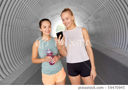 women or female friends with smartphone and flask women or female friends with smartphone and flask 59470945