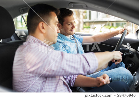 car driving school instructor teaching male driver car driving school instructor teaching male driver 59470946