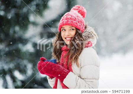 happy young woman with tea cup in winter park happy young woman with tea cup in winter park 59471199