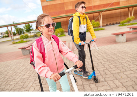 happy school children with backpacks and scooters happy school children with backpacks and scooters 59471201