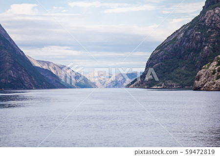 Scenic landscape View on the mountain peaks with green slopes and surface of water and feather Scenic landscape View on the mountain peaks with green slopes and surface of water and feather 59472819