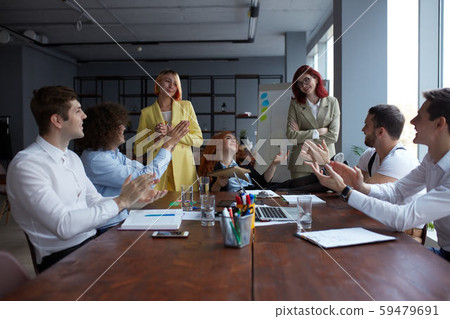 Happy business people gathered around table in office 59479691