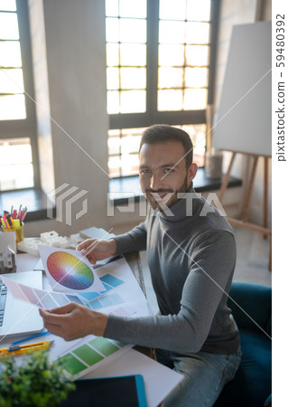 Smiling interior designer feeling good while working Smiling interior designer feeling good while working 59480392