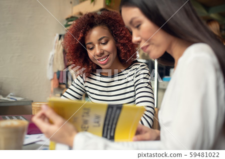 Businesswomen drinking latte and reading business books 59481022