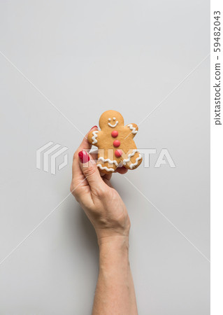 Female hand holding Christmas gingerbread cookies. Xmas greeting card. 59482043