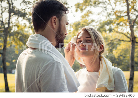 Young couples are wiping sweat after exercising. Young couples are wiping sweat after exercising. 59482406