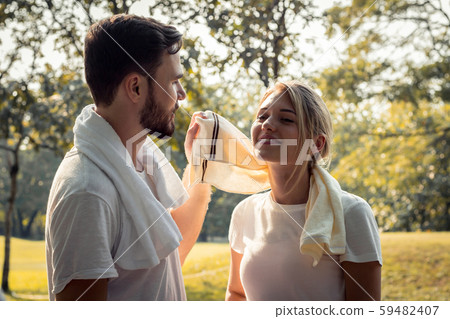Young couples are wiping sweat after exercising. 59482407