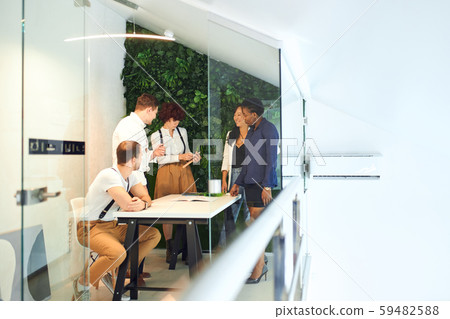 Co-workers gathered in modern office to discuss issues on the agenda Co-workers gathered in modern office to discuss issues on the agenda 59482588