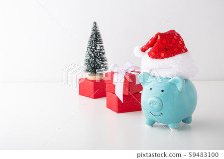 Piggy bank with christmas hat and red gift box on 59483100