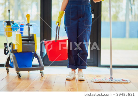 Unrecognizable worker of cleaning service using equipment for washing 59483651