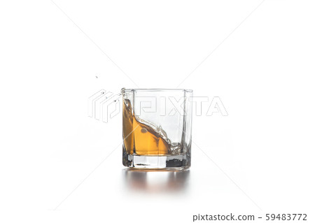 Whiskey splash in glass with ice on light Whiskey splash in glass with ice on light 59483772