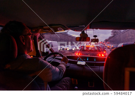 Driving a car in the city at night in traffic jams Driving a car in the city at night in traffic jams 59484017