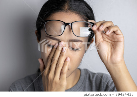 Women hold glasses and suffer from eye pain. Women hold glasses and suffer from eye pain. 59484433