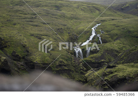 Beautiful river with tiny waterfall in Iceland surrounded by green hills Beautiful river with tiny waterfall in Iceland surrounded by green hills 59485366