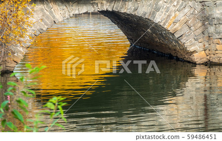 Stonework of a bridge pylon with reflection in the water Stonework of a bridge pylon with reflection in the water 59486451