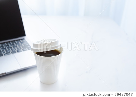 Working on a laptop while drinking coffee. Business or work. At-home work, telework and side jobs. Working on a laptop while drinking coffee. Business or work. At-home work, telework and side jobs. 59487047